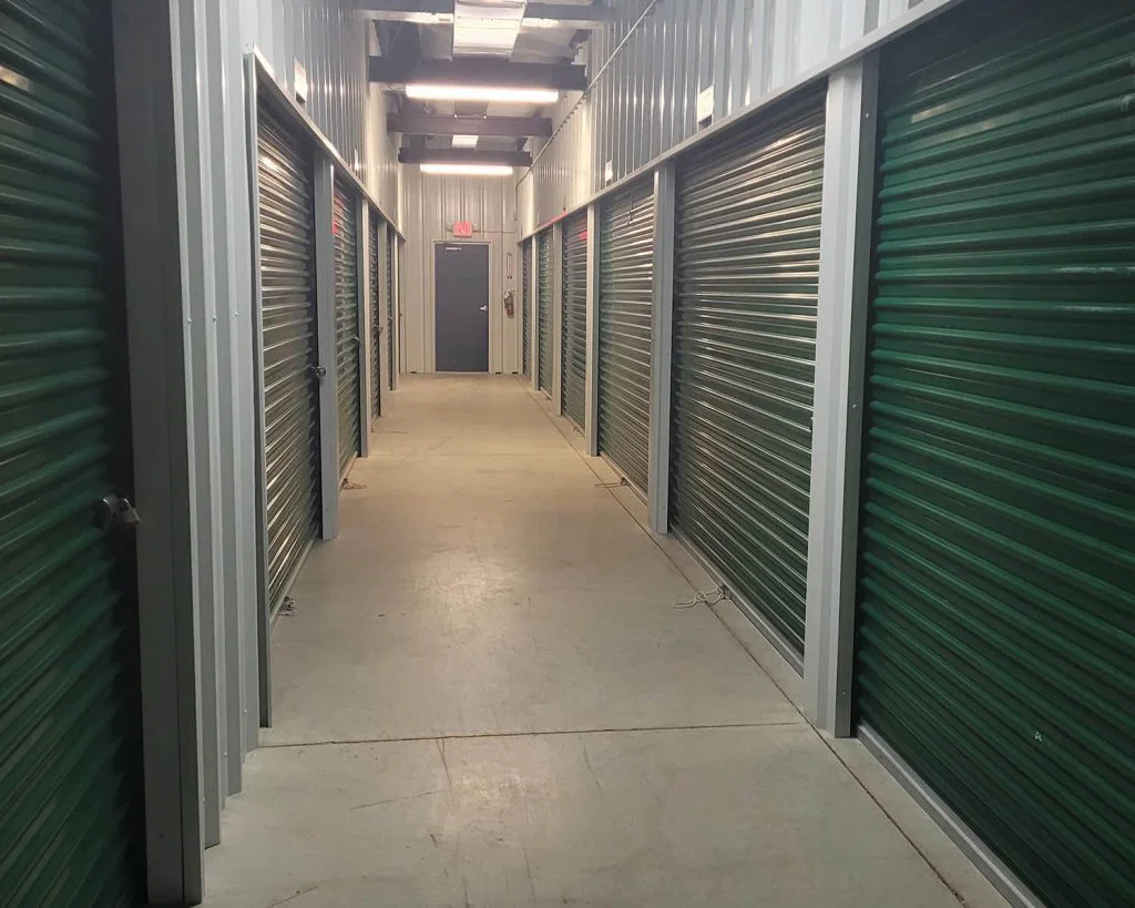 A hallway in a storage unit with multiple units represented by doors.